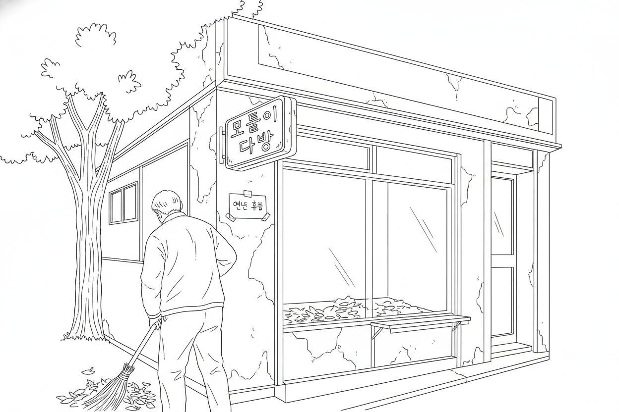 낙엽을 빗자루로 쓸어 모으는 상점 앞 풍경